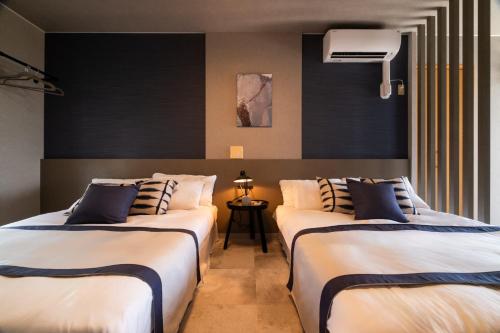 a room with two beds in a room with aperature at Alpha Terrace Motobu Hills in Motobu