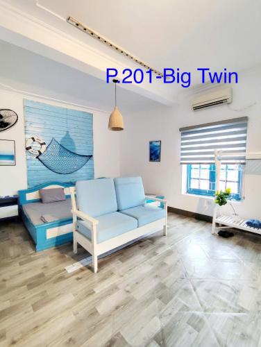 a living room with a couch and a table at Homestay Quan Lan - BLUE by MAY5 in Quan Lạn