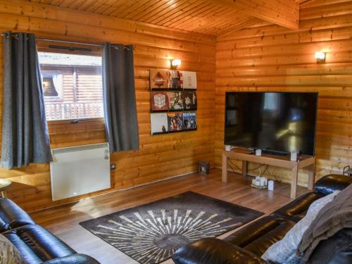 a living room with a couch and a flat screen tv at Kenwick Lodge - Uk37416 in Legbourne