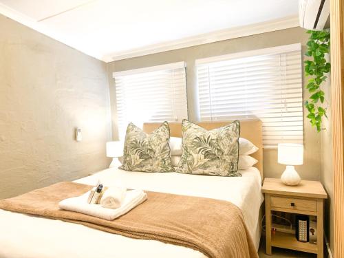 a bedroom with a bed with two pillows at The Boshoff in Durban
