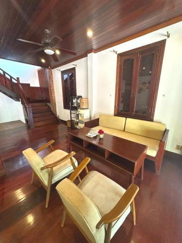 a living room with a couch and a table and chairs at Mekong Charm Sunset River View in Luang Prabang