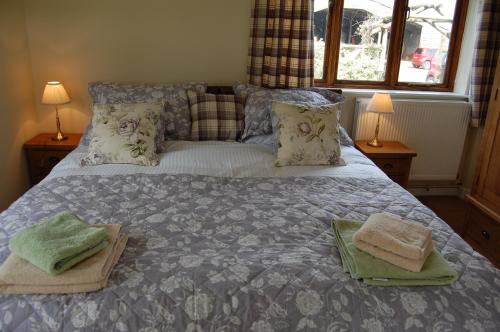 a bedroom with a bed with two towels on it at Woodway B&B in Blewbury