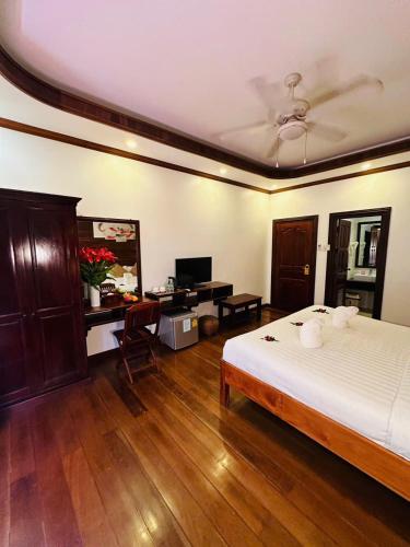 a bedroom with a bed and a desk with a computer at Mekong Charm Sunset River View in Luang Prabang