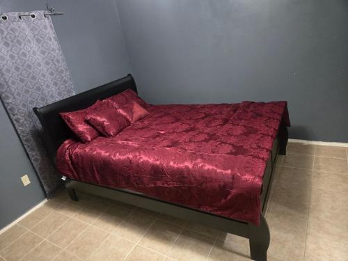 a bed with a red comforter in a room at fancy wonderful home! in Houston