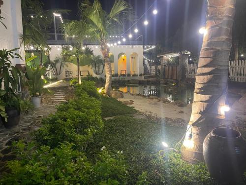 a backyard at night with a pond and palm trees at Sol Flow Retreat in Nguyên Ngoại