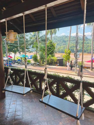 two swings on a porch with a view at Mekong Charm Sunset River View in Luang Prabang