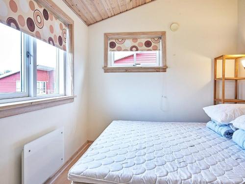 a bedroom with a bed and two windows at Modern Retreat by Golf Course - By Traum Ferienwohnungen in Gudhjem