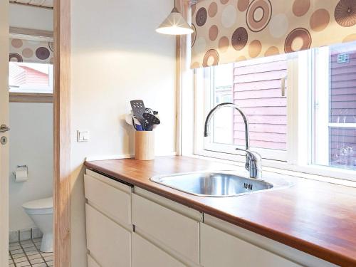 a kitchen with a sink and a window at Modern Retreat by Golf Course - By Traum Ferienwohnungen in Gudhjem