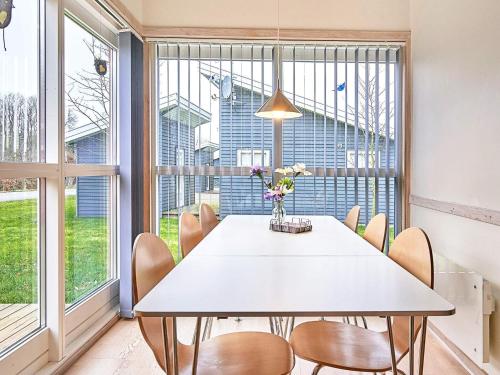 a dining room with a white table and chairs at Modern Retreat by Golf Course - By Traum Ferienwohnungen in Gudhjem