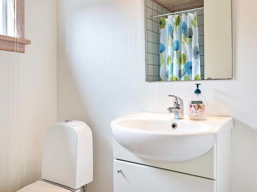 a bathroom with a sink and a toilet at Modern Retreat by Golf Course - By Traum Ferienwohnungen in Gudhjem