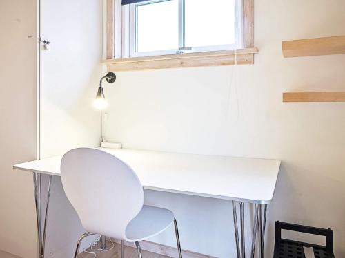a white desk and a white chair in a room at Modern Retreat by Golf Course - By Traum Ferienwohnungen in Gudhjem