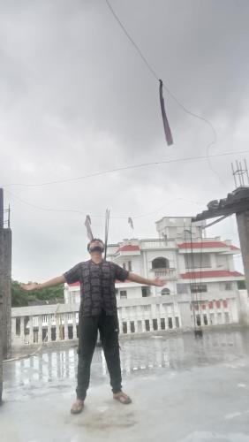 a man standing in the rain flying a kite at Ashrafi house in Lucknow