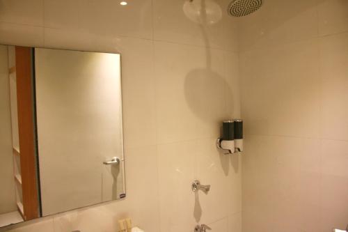 a bathroom with a mirror and a sink at LuxeLite Suites Pasay in Pasay