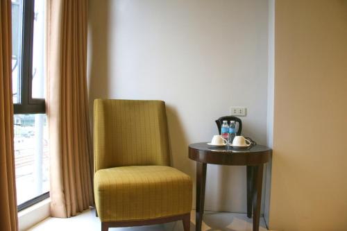 a room with a chair and a table and a window at LuxeLite Suites Pasay in Pasay