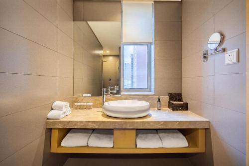 a bathroom with a sink and a mirror at Yitel Shenyang Sanhao Street Shengjing Hospital in Shenyang