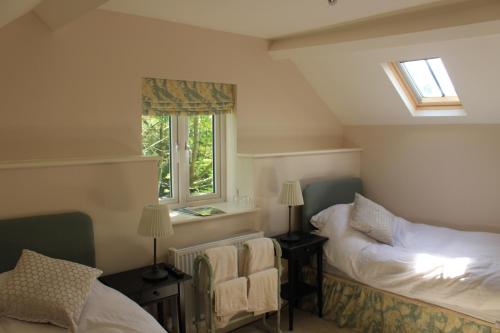 a small bedroom with two beds and a window at The Old Bakery Barn in Pattishall