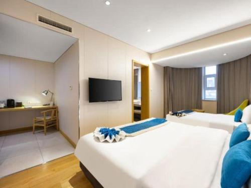 a hotel room with two beds and a flat screen tv at Yitel Shenyang Sanhao Street Shengjing Hospital in Shenyang