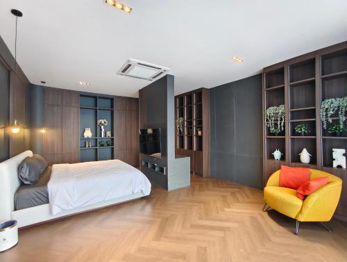 ein Schlafzimmer mit einem Bett und einem gelben Stuhl in der Unterkunft The Haven Boutique Pool Villa Morn2 , Chiang Mai in Chiang Mai