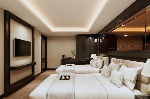a hotel room with two beds and a television at The Haron Hanoi Boutique Hotel in Hanoi