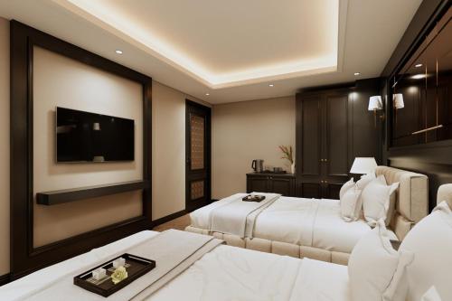 a hotel room with two beds and a flat screen tv at The Haron Hanoi Boutique Hotel in Hanoi