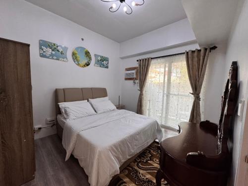 a bedroom with a bed and a piano and a window at Amani Grand Resort Residences Building C Unit 118 in Pusok