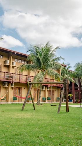 two palm trees in front of a building at Delta Maresias Club by Smart Sharing in Maresias