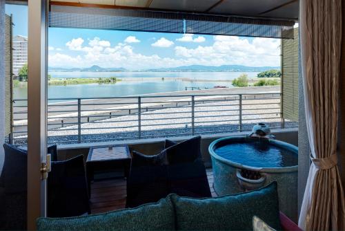 a balcony with a tub and a view of the water at Biwako Ryokusuitei in Otsu