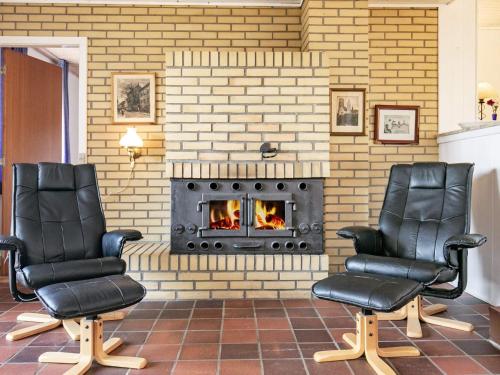 two chairs sitting in front of a fireplace at 8 person holiday home in Skagen in Skagen