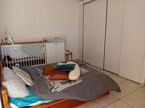 a bedroom with a crib with pillows on it at Villa détente avec jardin, idéalement située, Environnement Calme et Serein in La Possession