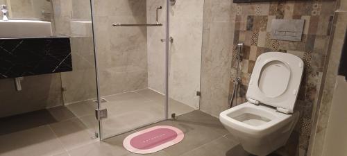 a bathroom with a shower and a toilet and a sink at Montecarlo Hotel in Mahabalipuram