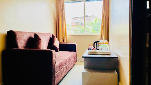 a living room with a red couch and a table at The Cristallo Resort in Shānti Niketan