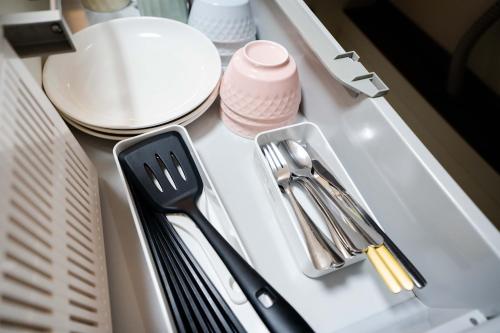 a kitchen counter with plates and utensils on it at 2 bedrooms and 1 living room on the 1st floor, 40sqm house, 10 min walk to Oji 2 min walk to Kajiyara Toden Arakawa Line in Wada