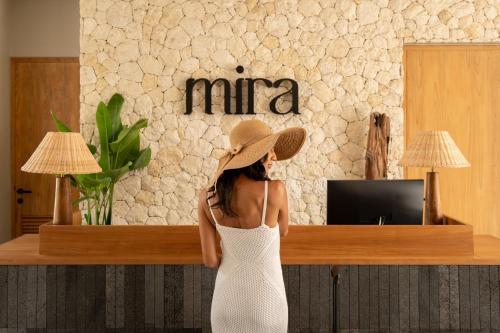a woman wearing a hat standing in front of a counter at Mira Hotel and Recovery in Uluwatu