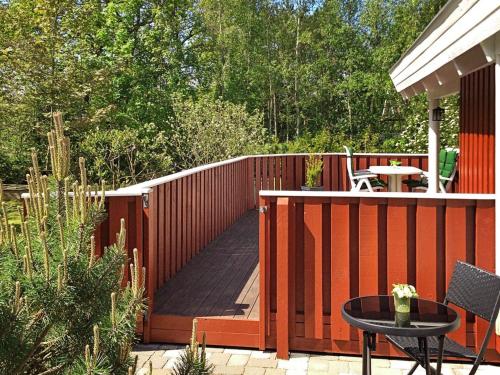 a wooden deck with a table and a patio at 6 person holiday home in Hadsund in Øster Hurup