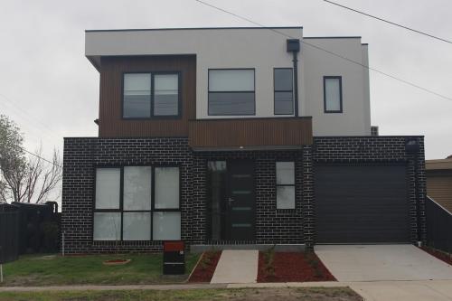 a brick house with a black garage at Springvale Family Friendly Home Best Location in Springvale