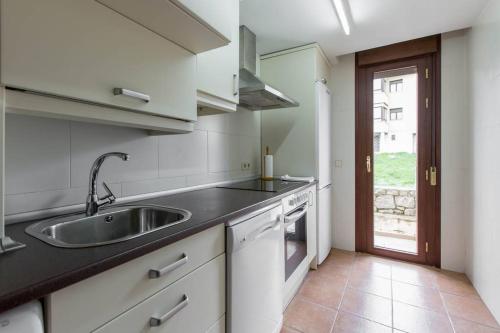 una cocina con fregadero y encimera en Alojamientos Botica Rural, en La Cabrera