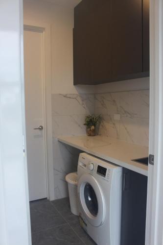 a kitchen with a washing machine and a counter at Springvale Family Friendly Home Best Location in Springvale