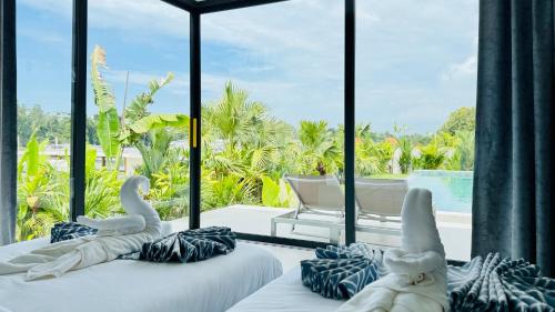 two swan beds in a room with a view of a pool at Suan Serenity Villa in Koh Samui