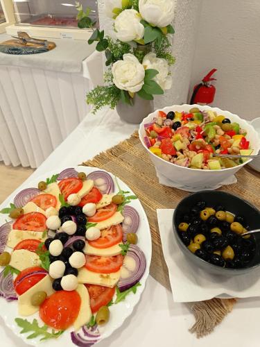 a table with two plates of food and a salad at Hotel Riva Kaštela with swimming pool in Kaštela