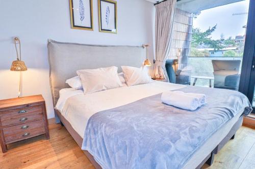 una camera da letto con un letto grande e una finestra di HOM I Depto TOP1 con Estacionamiento en Puerto Varas a Puerto Varas