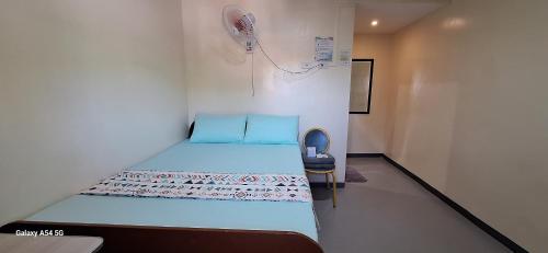 a small room with a bed and a fan at Rain Haven Lodging House in Coron