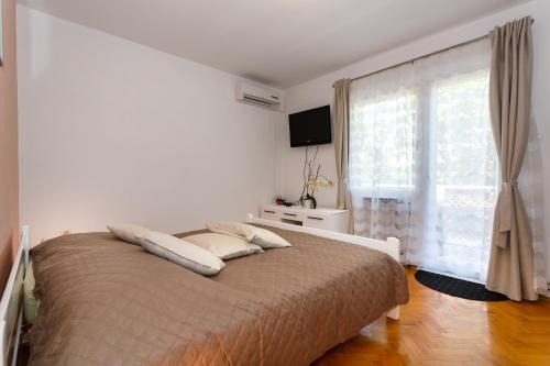 a bedroom with a bed and a large window at Apartments Dorotea in Krk