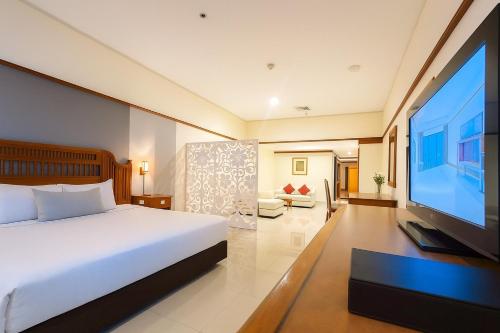 a bedroom with a bed and a flat screen tv at Loei Palace Hotel in Loei