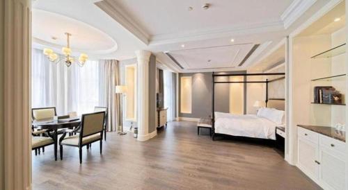 a bedroom with a bed and a desk and a table at Yin Run Jin Jiang Castle Hotel in Huzhou