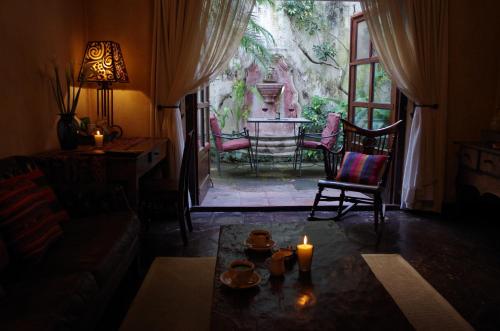 a living room with a candle and a table and chairs at Meson Panza Verde in Antigua Guatemala