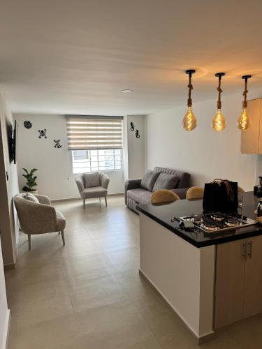 eine Küche und ein Wohnzimmer mit Sofa und Tisch in der Unterkunft Apartamento vacacional San Gil in San Gil