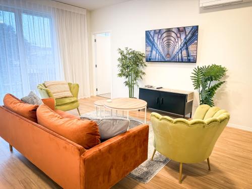 a living room with a couch and chairs and a table at Modern 3Bdr 2bath Apartment Beach Golf Shops Relax in Paraparaumu Beach