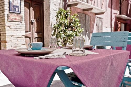 a table with a purple table cloth and a blue chair at Antica Dimora San Girolamo in Licata