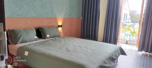 a bedroom with a large bed with a large window at Marea Villa Hoi An in An Bang