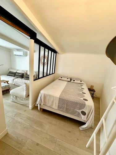 una camera da letto con due letti e una grande finestra di Charmante maison a Vallauris